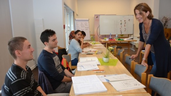 Grundkurs Deutsch: Altin, Mustafa und Mitra (von links) machen mit Lehrerin Isabell Münzenberg die ersten Schritte in der fremden Sprache. Foto: Thieme